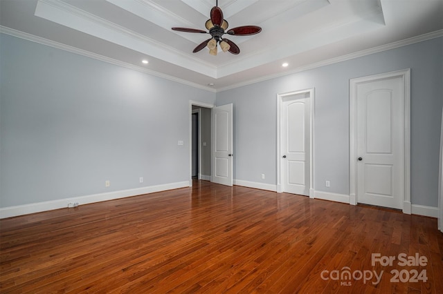 unfurnished bedroom with ceiling fan, hardwood / wood-style flooring, a tray ceiling, and crown molding