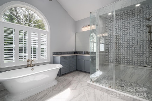 bathroom with vanity, shower with separate bathtub, and vaulted ceiling