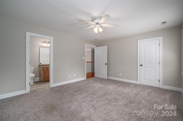 unfurnished bedroom with ceiling fan, carpet floors, and ensuite bath