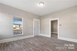 unfurnished bedroom with dark wood-type flooring, a closet, and a spacious closet