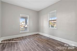 empty room with hardwood / wood-style floors and a wealth of natural light