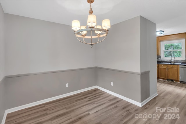 interior space with light wood-type flooring, an inviting chandelier, and sink