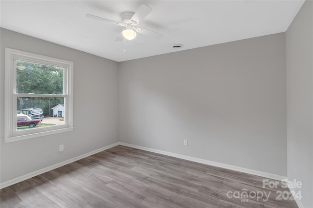 empty room with light wood-type flooring, ceiling fan, and a wealth of natural light