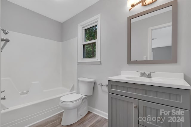 full bathroom with hardwood / wood-style floors, vanity, bathing tub / shower combination, and toilet