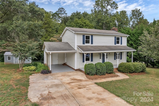 view of property with a porch, a front lawn, a storage unit, and a carport