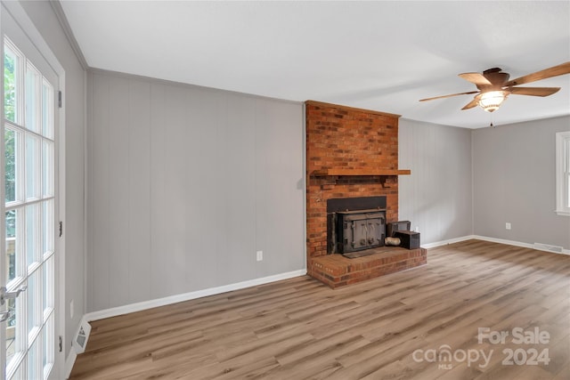 unfurnished living room featuring light hardwood / wood-style flooring, ceiling fan, a fireplace, and crown molding