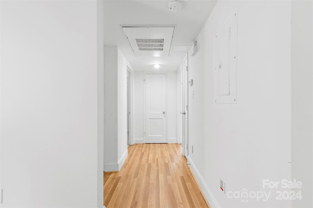 hall featuring electric panel and light hardwood / wood-style floors