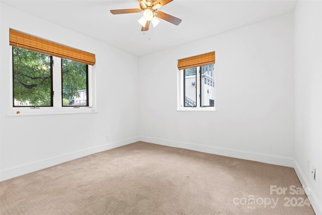 carpeted spare room featuring ceiling fan