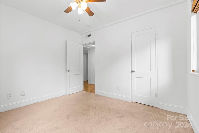 unfurnished bedroom with ceiling fan and light carpet