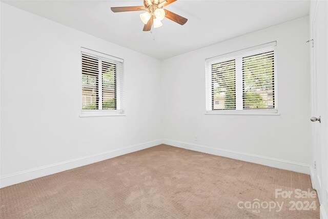 unfurnished room featuring light colored carpet and ceiling fan