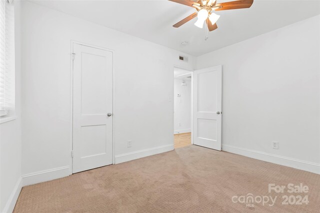 carpeted empty room featuring ceiling fan