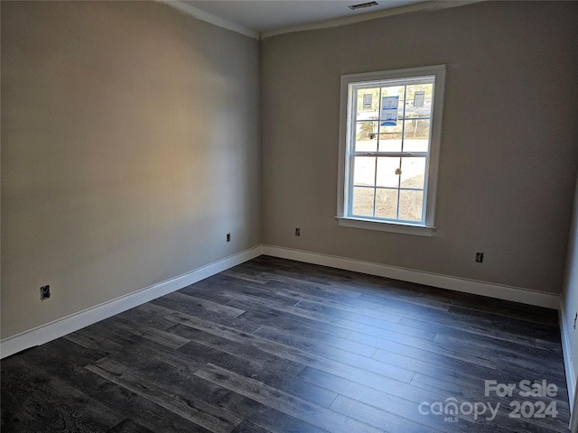 spare room featuring dark hardwood / wood-style flooring and ornamental molding