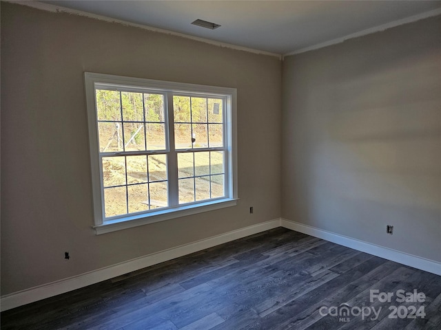 spare room featuring dark hardwood / wood-style floors and crown molding