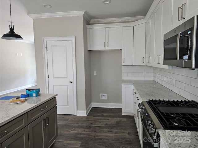 kitchen featuring stainless steel appliances, white cabinetry, light stone counters, and decorative light fixtures