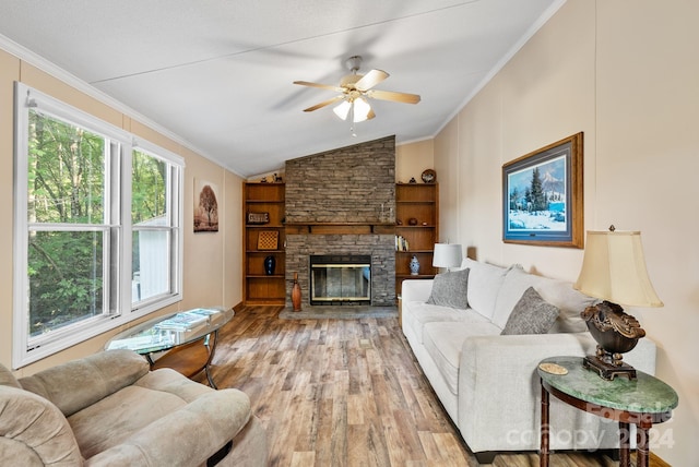 living room with light hardwood / wood-style floors, a stone fireplace, and crown molding