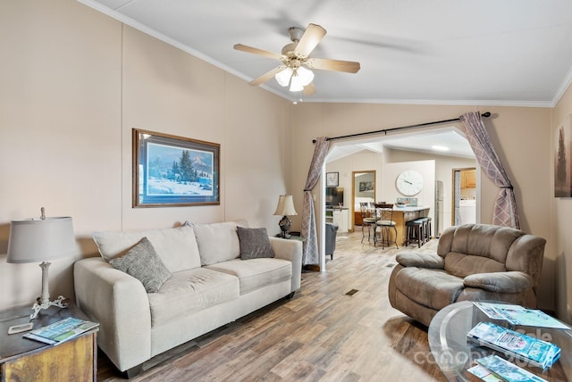 living room featuring hardwood / wood-style floors, ceiling fan, lofted ceiling, and crown molding