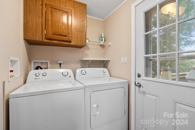 clothes washing area featuring washing machine and dryer, crown molding, cabinets, and a textured ceiling