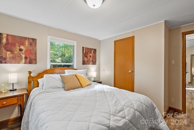 bedroom featuring a textured ceiling, hardwood / wood-style flooring, and crown molding