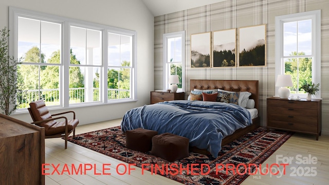 bedroom with light hardwood / wood-style floors and lofted ceiling