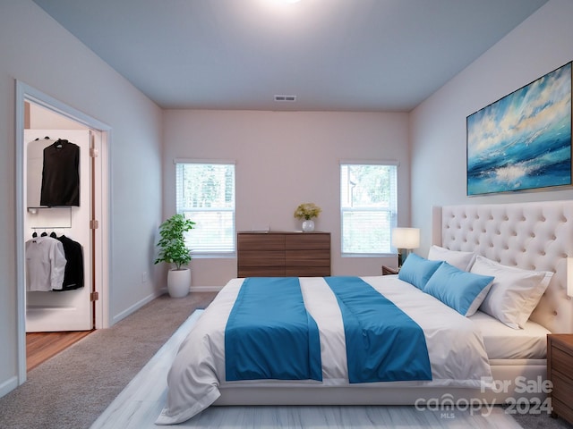 bedroom with light colored carpet and multiple windows