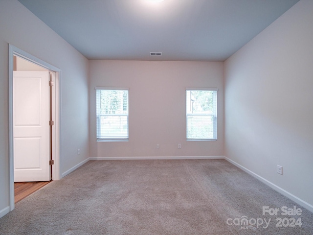 carpeted spare room featuring plenty of natural light