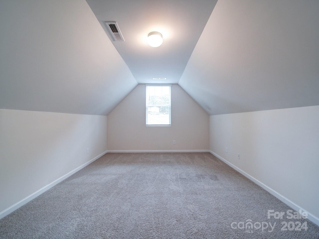 bonus room featuring lofted ceiling and carpet flooring