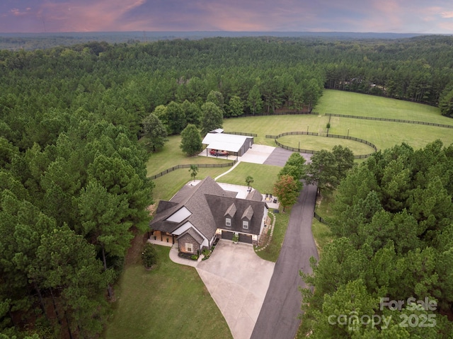 birds eye view of property with a rural view and a wooded view