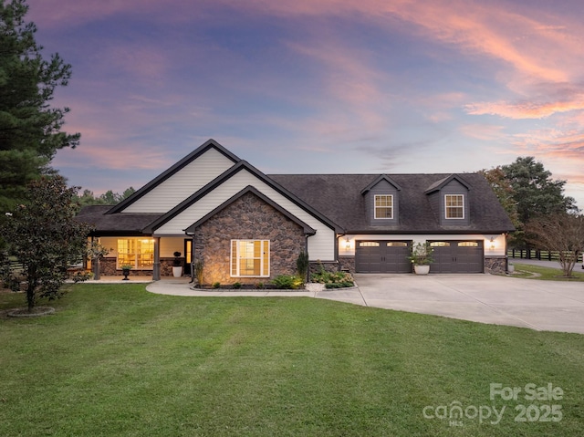 view of front of home featuring a front lawn, stone siding, concrete driveway, a shingled roof, and a garage