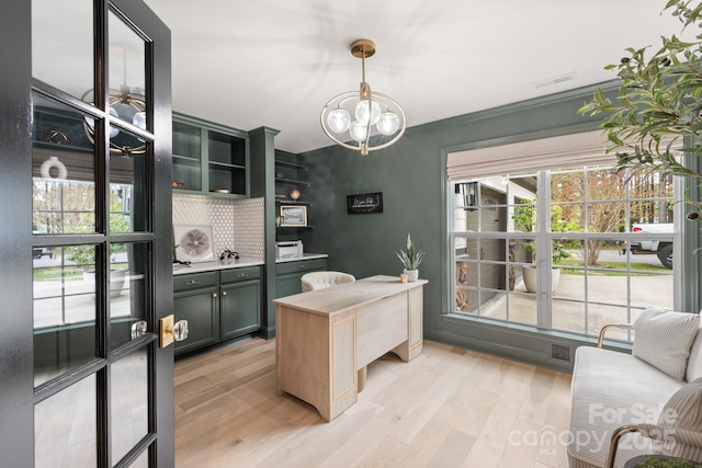 home office with light wood-type flooring, visible vents, a chandelier, and crown molding