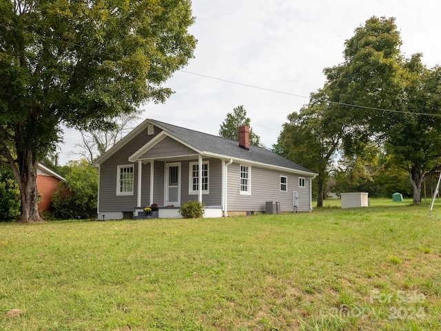 view of front of home with a front lawn and central air condition unit