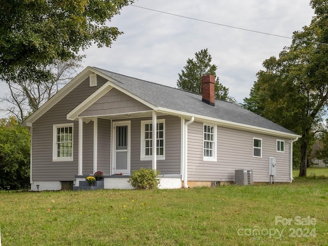 view of front of property featuring central AC unit and a front yard