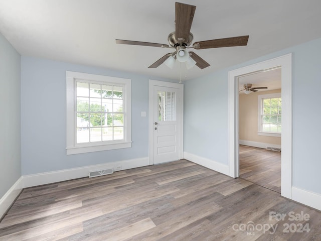 foyer entrance with ceiling fan and light wood-type flooring