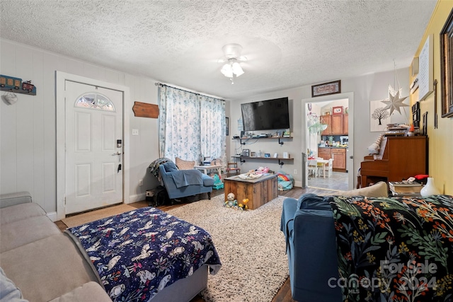 living room with ceiling fan and a textured ceiling