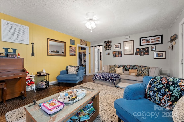 living room with dark hardwood / wood-style flooring and a textured ceiling