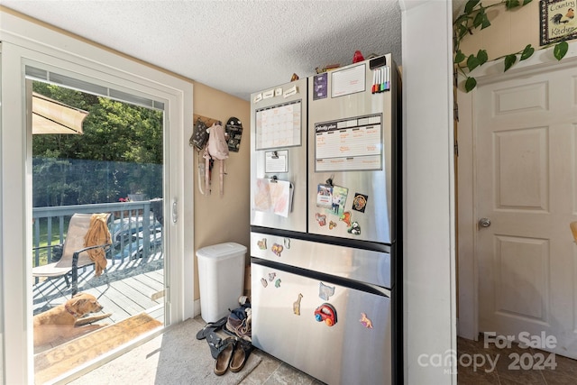 kitchen featuring stainless steel fridge and a textured ceiling