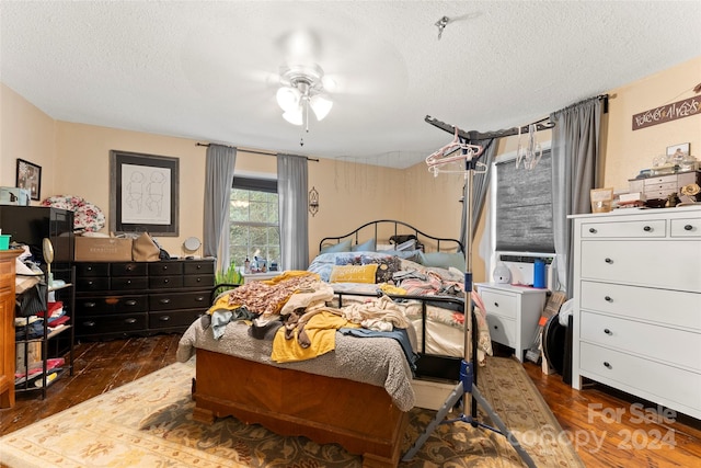 bedroom featuring ceiling fan, dark hardwood / wood-style floors, and a textured ceiling