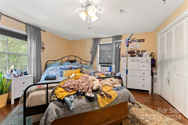 bedroom featuring a textured ceiling, ceiling fan, a closet, and dark hardwood / wood-style flooring