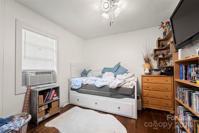 bedroom featuring dark wood-type flooring, a textured ceiling, cooling unit, and ceiling fan