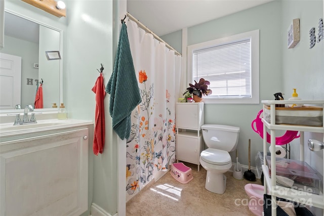 bathroom featuring vanity, toilet, and walk in shower