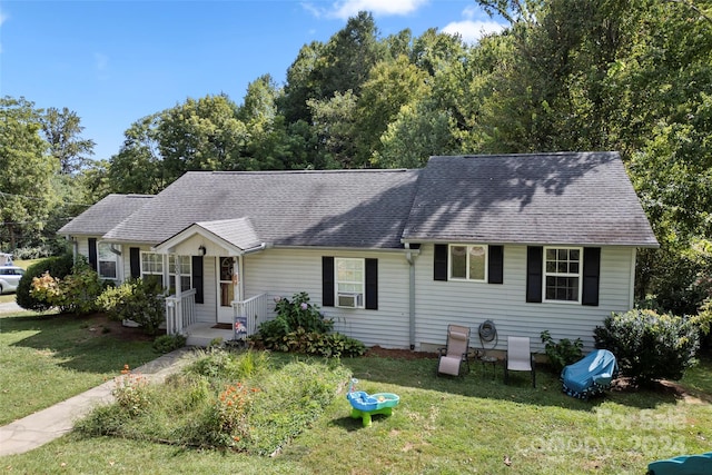 ranch-style home with cooling unit and a front lawn