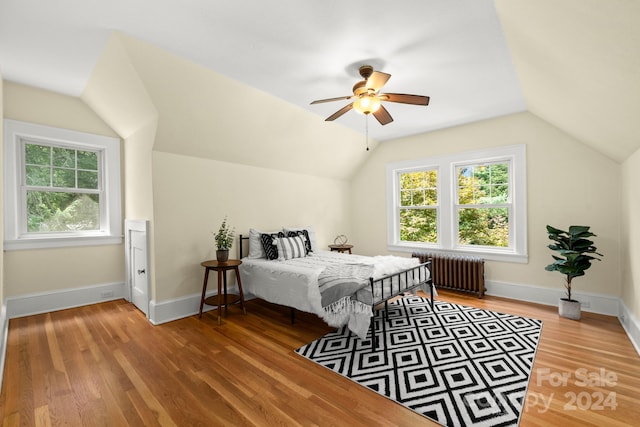 bedroom featuring lofted ceiling, ceiling fan, hardwood / wood-style floors, and radiator heating unit