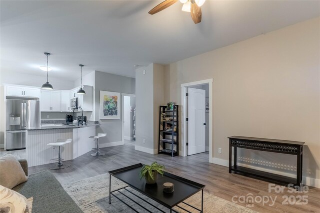 living room featuring ceiling fan and light wood-type flooring