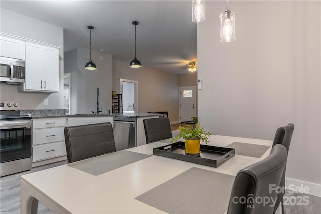 dining room featuring sink, ceiling fan, and light hardwood / wood-style flooring