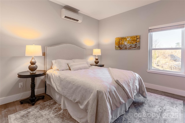 bedroom featuring multiple windows, wood-type flooring, and an AC wall unit