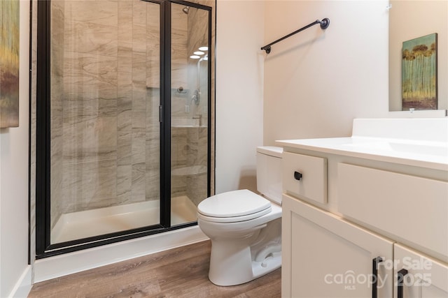 bathroom with vanity, a shower with shower door, wood-type flooring, and toilet