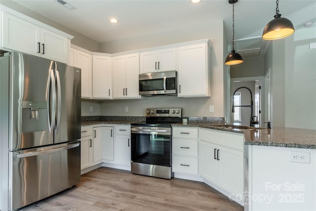 kitchen with white cabinetry, appliances with stainless steel finishes, sink, and decorative light fixtures