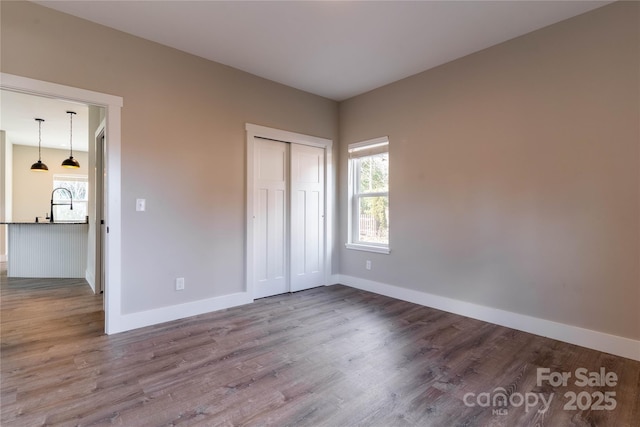 unfurnished bedroom featuring wood-type flooring and a closet