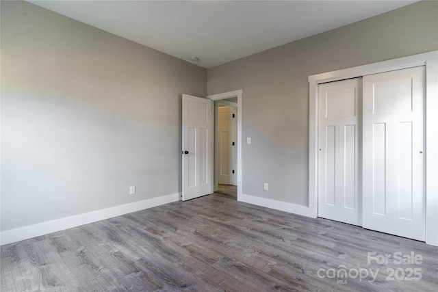 unfurnished bedroom featuring light hardwood / wood-style flooring and a closet