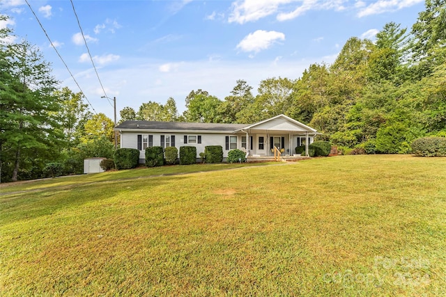 ranch-style house with a front lawn, a shed, and covered porch