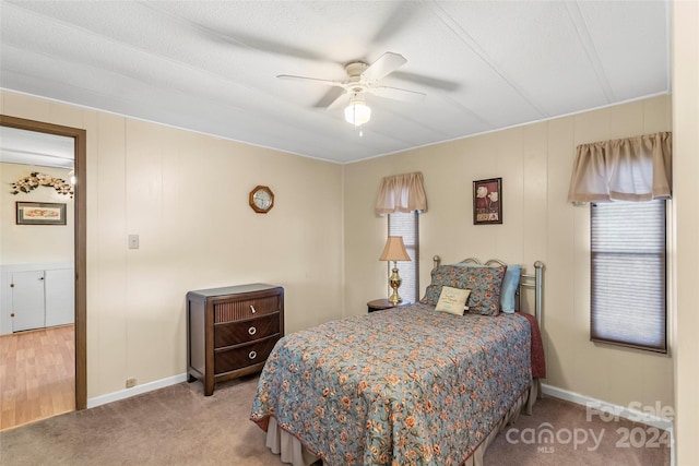 bedroom featuring a textured ceiling, light colored carpet, ceiling fan, and multiple windows